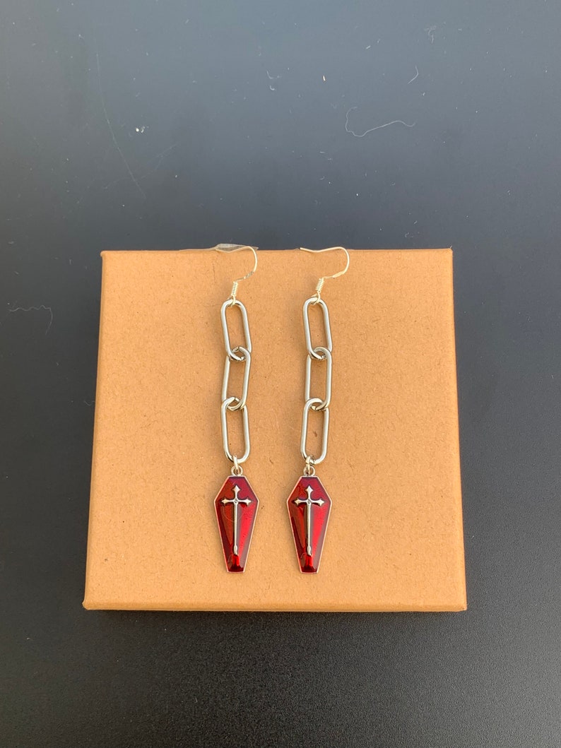 This image shows the earrings against a cardboard background.