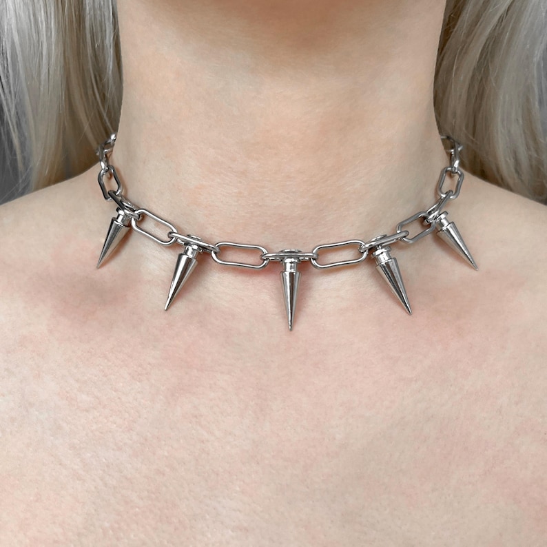 Punk spike choker necklace with stainless steel chain and silver plated cone spike charms worn around neck