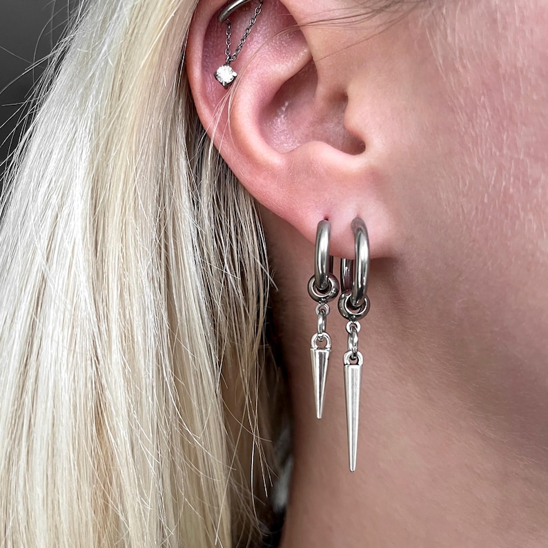 Gothic silver spike huggie hoop earrings. Perfect for stacked ear lobes. Silver huggie hoop with spike. Trendy punk aesthetic.
