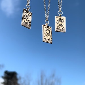 Another image of the tarot card necklaces. This image is taken outside, in natural daylight to best represent how the necklaces look like in real life.