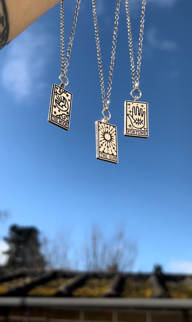 Another image of the tarot card necklaces. This image is taken outside, in natural daylight to best represent how the necklaces look like in real life.