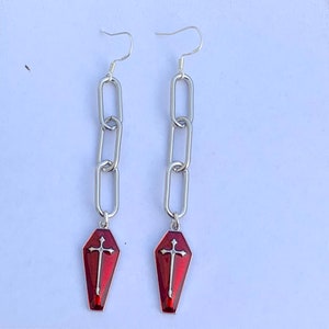 The coffin charms dangle from the centre of the last silver chain link. The earrings are quite long. Please see the item description for exact measurements of these earrings.