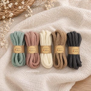 May include: Five bundles of thick, braided cotton cord in sage green, dusty rose, cream, tan, and charcoal gray. Each bundle is secured with a tan paper band printed with the text 'handmade with love' and a small red heart icon.