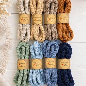 May include: Eight bundles of thick, braided cotton cord in various colors including cream, tan, brown, mustard, sage green, light blue, medium blue, and navy. Each bundle is secured with a brown paper label reading handmade with love.
