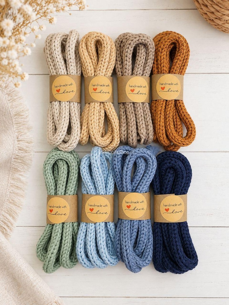 May include: Eight bundles of thick, braided cotton cord in various colors including cream, tan, brown, mustard, sage green, light blue, medium blue, and navy. Each bundle is secured with a brown paper label reading handmade with love.