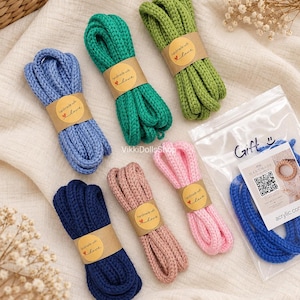 May include: Six bundles of braided acrylic cord in blue, green, lime, navy, dusty rose, and pink. Each bundle is wrapped in a brown paper band labeled "handmade with love" with a heart icon. One blue cord is inside a clear plastic gift bag.