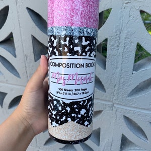 May include: A pink and black glitter tumbler with a white label that says "Composition Book" and "Mrs. Mundo". The label also says "100 Sheets 200 Pages 9 3/4 x 7 1/2 in / 24.7 x 19.0 cm".