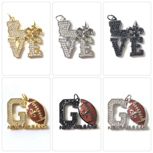 Pu&ograve; includere: Tre set di ciondoli che presentano la parola "LOVE" con un giglio e la lettera "G" con un pallone da calcio e le parole "NEW ORLEANS". I ciondoli sono disponibili in oro, argento e nero.