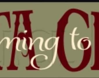 May include: A rectangular sign with the text "SANTA CLAUS is coming to town" in a festive, arched design. The words "SANTA CLAUS" are in a bold, dark red font, while "is coming to town" is in a lighter, cursive font. The background is a muted green.
