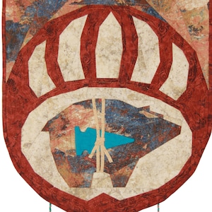 May include: A red, white, and blue quilted wall hanging with a bear paw design and turquoise beads hanging from the bottom.