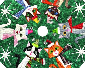 May include: A green Christmas tree skirt with a 48-inch diameter featuring a paper pieced pattern of cats wearing Santa hats and scarves. The text "Here Comes Santa Claws" and "PreFurred Quilts" is printed on the image.