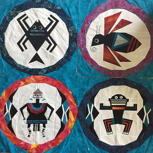 May include: Four white circles with black outlines on a blue background. Each circle contains a different black and white illustration of a creature. The top left circle has a spider, the top right circle has a bee, the bottom left circle has a person, and the bottom right circle has a frog.