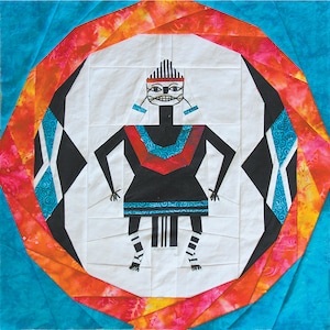 May include: A colorful quilt block with a stylized figure in the center. The figure is black with white and blue accents. The background is a swirling pattern of orange, red, and blue.