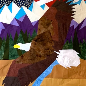 May include: A brown and white eagle with a yellow beak flying over a mountain range with purple peaks and a blue sky. The mountains are in front of an American flag.