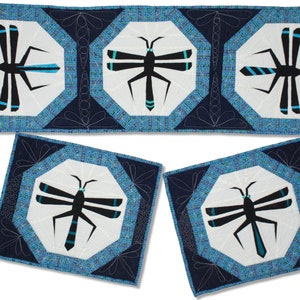 May include: A set of four quilted table runners and placemats featuring a dragonfly design. The fabric is blue, white, and black with a geometric pattern.