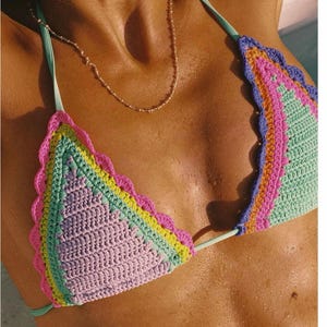Puede incluir: Top de bikini de ganchillo multicolor con borde festoneado. El top triangular presenta una combinación de colores pastel rosa, verde, amarillo y morado. Las correas son de color verde azulado claro.
