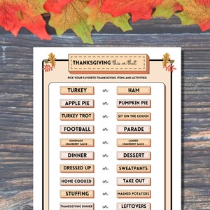 Thanksgiving This or That printable activity for autumn dinner parties is shown on a wooden background with colorful fall leaves at the top.