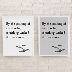 Può includere: Due stampe incorniciate con la citazione "By the pricking of my thumbs, something wicked this way comes." Le stampe presentano illustrazioni di pipistrelli. Una stampa ha sfondo bianco, l'altra è grigia.