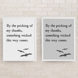 By the pricking of my thumbs, something wicked this way comes. Halloween literary quote art print from Macbeth by Shakespeare hangs on the wall in two colors - white and gray. Spooky literary print also has images of bats in lower right corner.