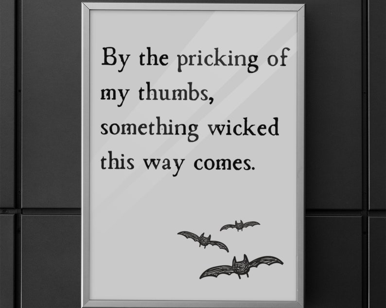 By the pricking of my thumbs, something wicked this way comes. -Macbeth by Shakespeare

Minimalistic Halloween print with bat design and gray background hangs on a black wall making for perfect spooky season Halloween decoration for classroom or home