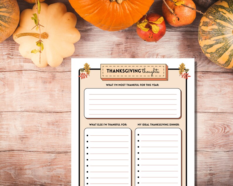 Thanksgiving Thoughts printable writing prompt sheet is shown on a light wooden table with bright orange pumpkins and autumn fruits.