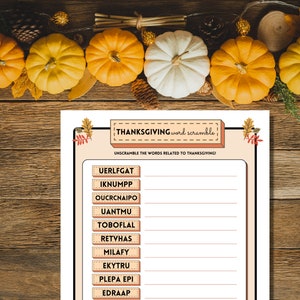 Thanksgiving word scramble printable activity is shown on a wooden table lined with pumpkins, fall leaves, and pine cones.
