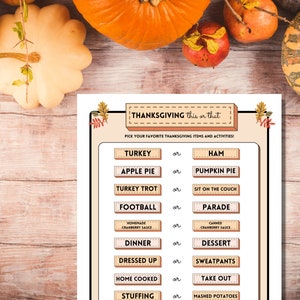 Thanksgiving This or That printable holiday party game is shown on a light wooden table lined with bright autumn pumpkins and fall fruits.