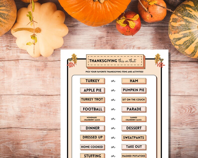 Thanksgiving This or That printable holiday party game is shown on a light wooden table lined with bright autumn pumpkins and fall fruits.