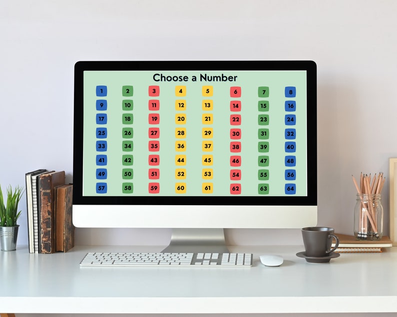 May include: A computer screen displaying a grid of numbers from 1 to 64, with each number in a colored square. The screen reads "Choose a Number". The computer is on a white desk with a keyboard, mouse, and a cup of coffee.