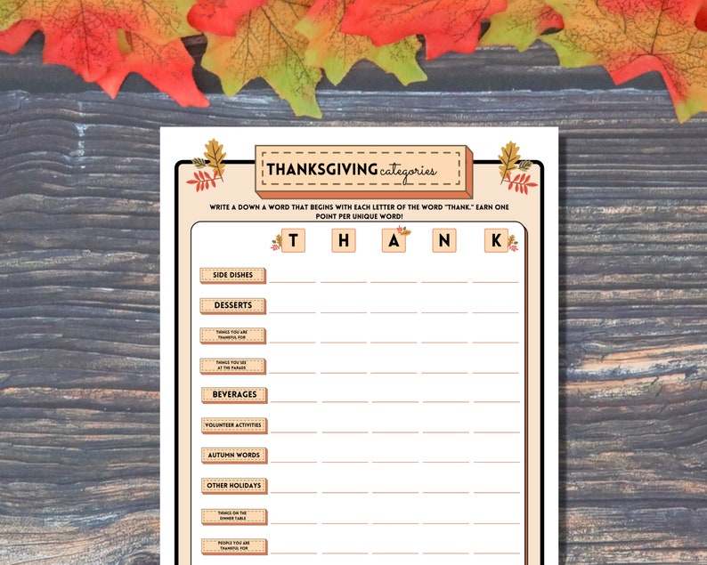 Printable Autumn party word game Thanksgiving Categories is shown on a wooden background lined with orange and green fall leaves.