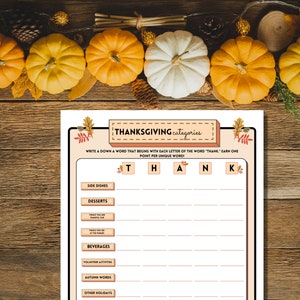 Thanksgiving Categories Scattegories-type game is shown on a wood table with pumpkins at the top.