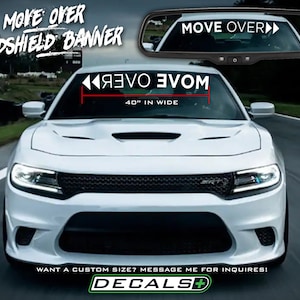 May include: White car with a windshield banner that reads "MOVE OVER" in white text. The banner is 40 inches wide. The image also shows the text "WINDSHIELD BANNER" and "DECALS+".