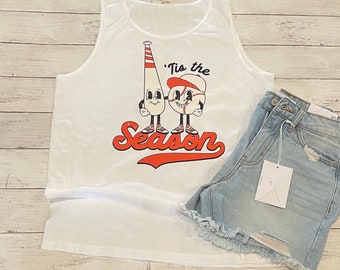 Può includere: Canotta bianca con una grafica a tema baseball rosso, bianco e blu che dice "'Tis the Season".