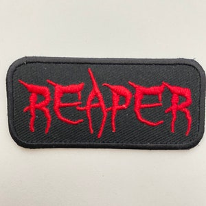 May include: Black embroidered patch with the word "REAPER" in red lettering.
