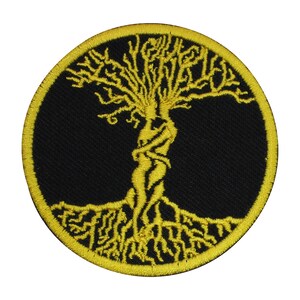 May include: A yellow embroidered patch featuring a tree of life with detailed branches and roots. The tree is set against a black background and is enclosed by a yellow border.