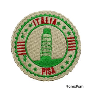 May include: Beige embroidered patch with a green and white image of the Leaning Tower of Pisa. The patch is surrounded by red and white stripes and stars. The text "ITALIA" and "PISA" are embroidered in red. The patch is 9 cm by 9 cm.