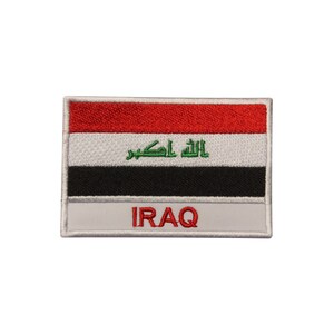 May include: An embroidered patch featuring the flag of Iraq. The patch is white with a red, white, black, and green flag in the center. The words "IRAQ" are written in red below the flag.