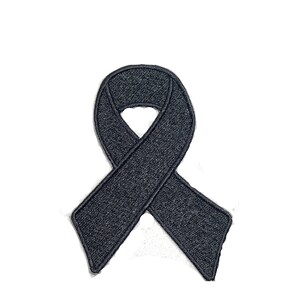 Peut inclure: Écusson brodé en forme de ruban noir.