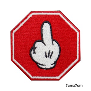 May include: Red octagonal stop sign with a white cartoon hand giving the middle finger. The sign is 7cm by 7cm.