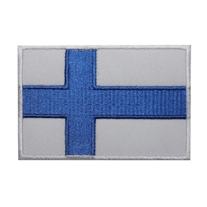 May include: A white fabric patch with a blue cross in the center. The patch is surrounded by a white border.
