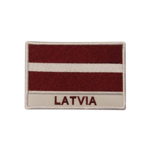 May include: Embroidered patch featuring the Latvian flag with a white stripe on a maroon background. The patch has a white border and the word "LATVIA" is written in maroon below the flag.