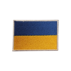 May include: Embroidered patch featuring the flag of Ukraine. The rectangular patch displays a horizontal bicolor design with a blue upper half and a yellow lower half, outlined with a white border. The patch is likely for clothing or accessories.