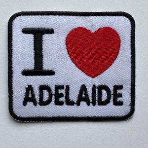 May include: White square patch with black embroidered text "I love Adelaide" and a red heart.