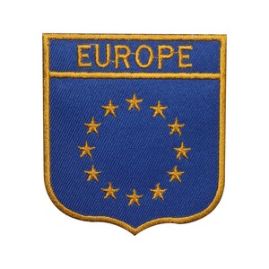 Könnte beinhalten: Ein blauer und goldener gestickter Aufnäher mit dem Wort "EUROPE" und einem Kreis aus 12 goldenen Sternen.