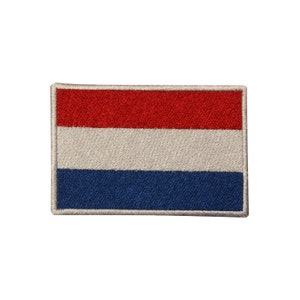 May include: A red, white, and blue embroidered patch of the Dutch flag.