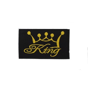 Peut inclure: Un écusson brodé noir avec une couronne dorée et le mot "King" en écriture cursive dorée.