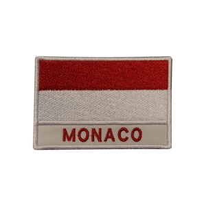 May include: A white and red embroidered patch with the word "MONACO" in red lettering.