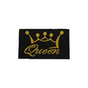 May include: A black embroidered patch with a gold crown and the word "Queen" in a cursive font.