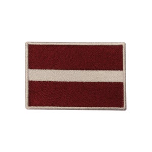 May include: A red and white embroidered patch featuring the flag of Latvia. The patch has a white border.