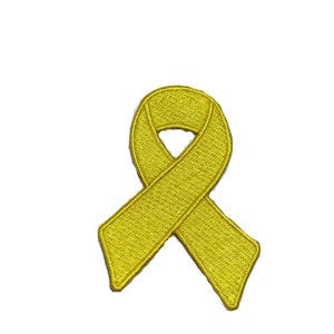 May include: A yellow ribbon patch, embroidered with a textured appearance. The ribbon is looped and crossed, a symbol of support and awareness. The patch is set against a white background.